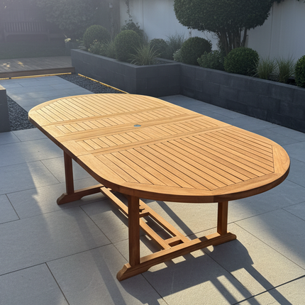 Wooden outdoor table on a patio with trees and a building in the background