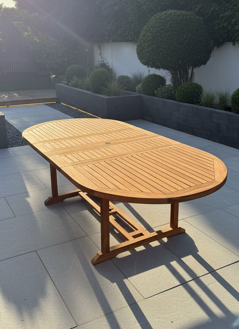 Wooden outdoor table on a patio with trees and a building in the background
